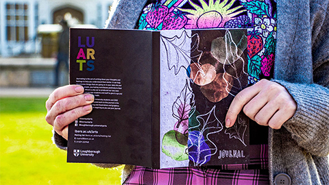 A person holding the LU Arts Journal.